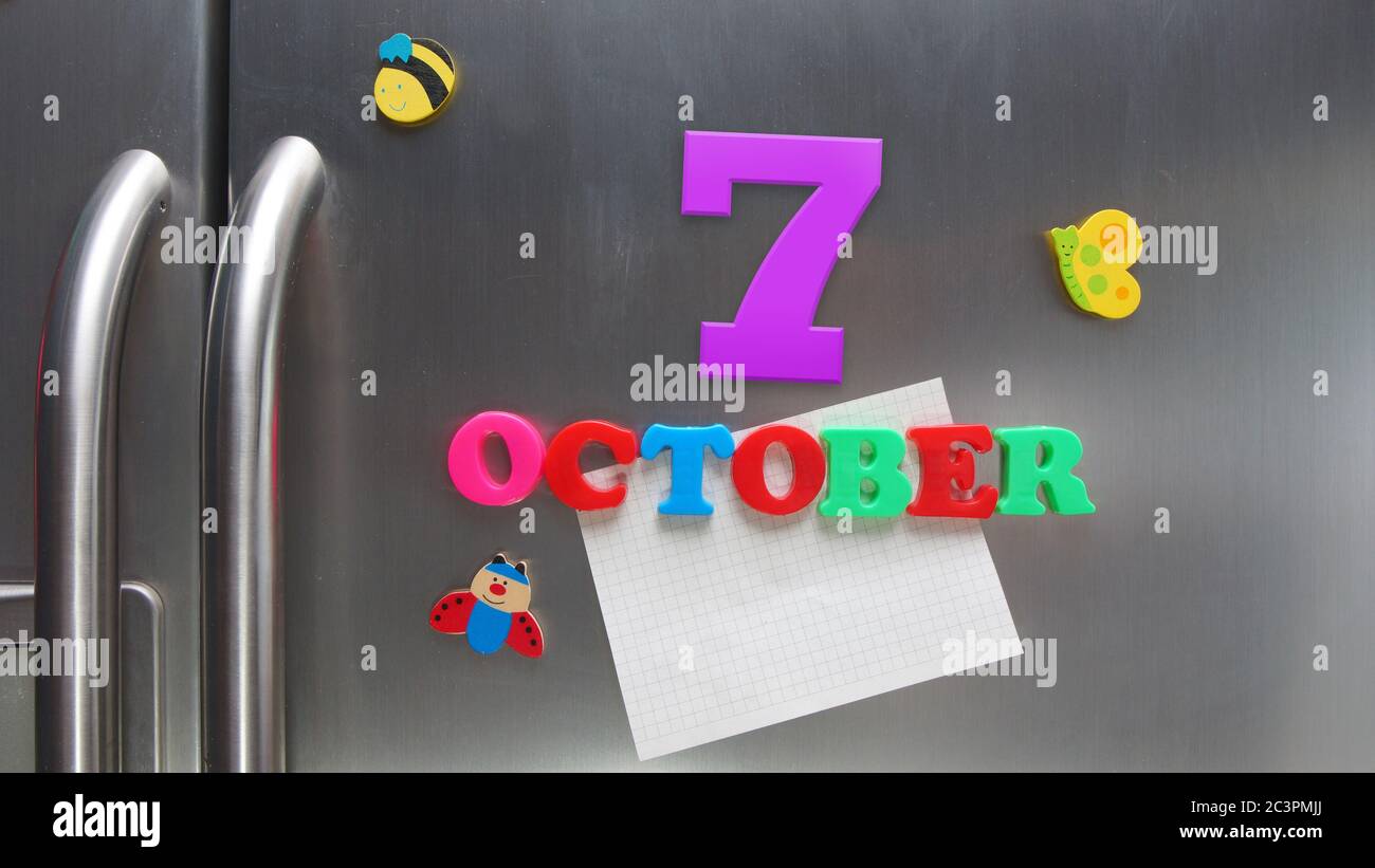 October 7 calendar date made with plastic magnetic letters holding a note of graph paper on door refrigerator Stock Photo