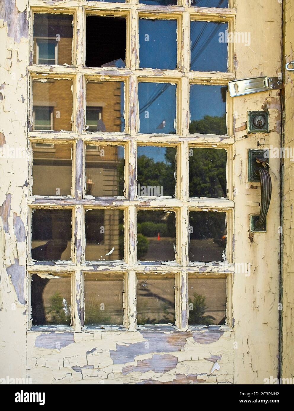 reflections in an abandoned buildings door windows Stock Photo