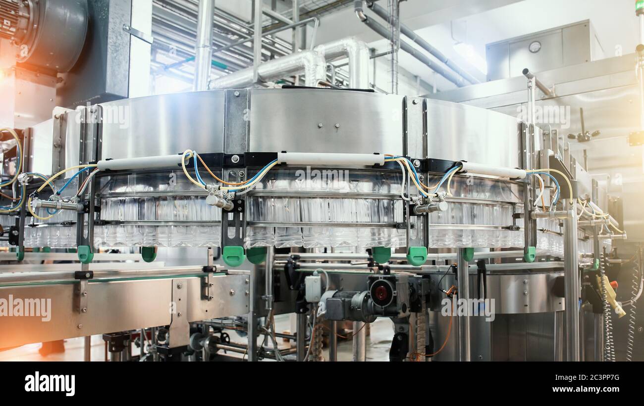 Industrial machine conveyor with plastic bottles in beverage factory, industry equipment. Stock Photo