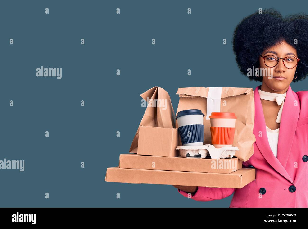 Young african american girl wearing business clothes holding delivery food with angry face