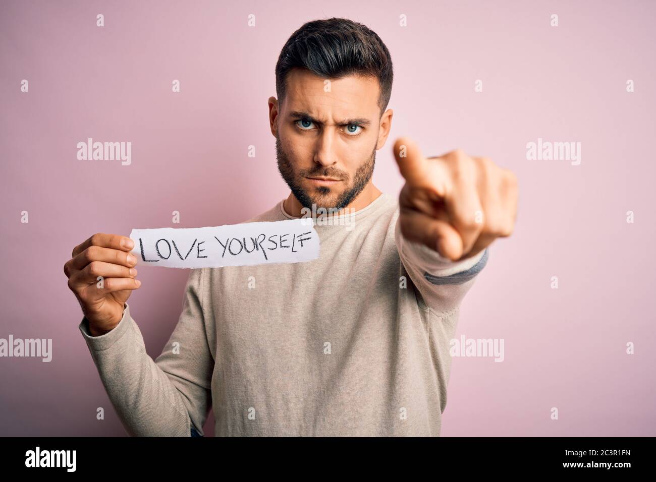 Young Handsome Man Holding Paper With Self Love Message Over Pink Background Pointing With Finger To The Camera And To You Hand Sign Positive And Co Stock Photo Alamy