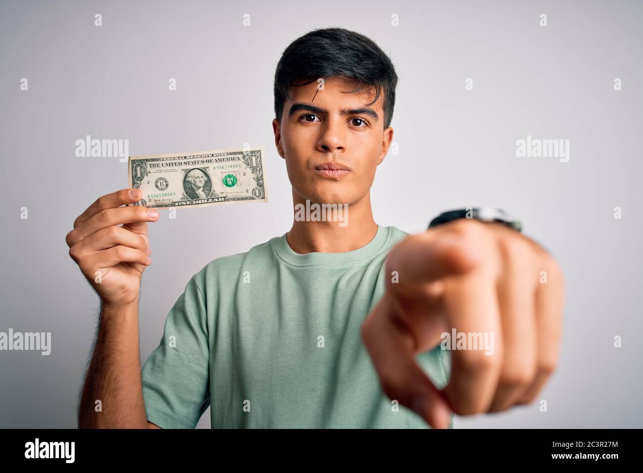 Young handsome man holding one dollar banknotes over isolated white ...