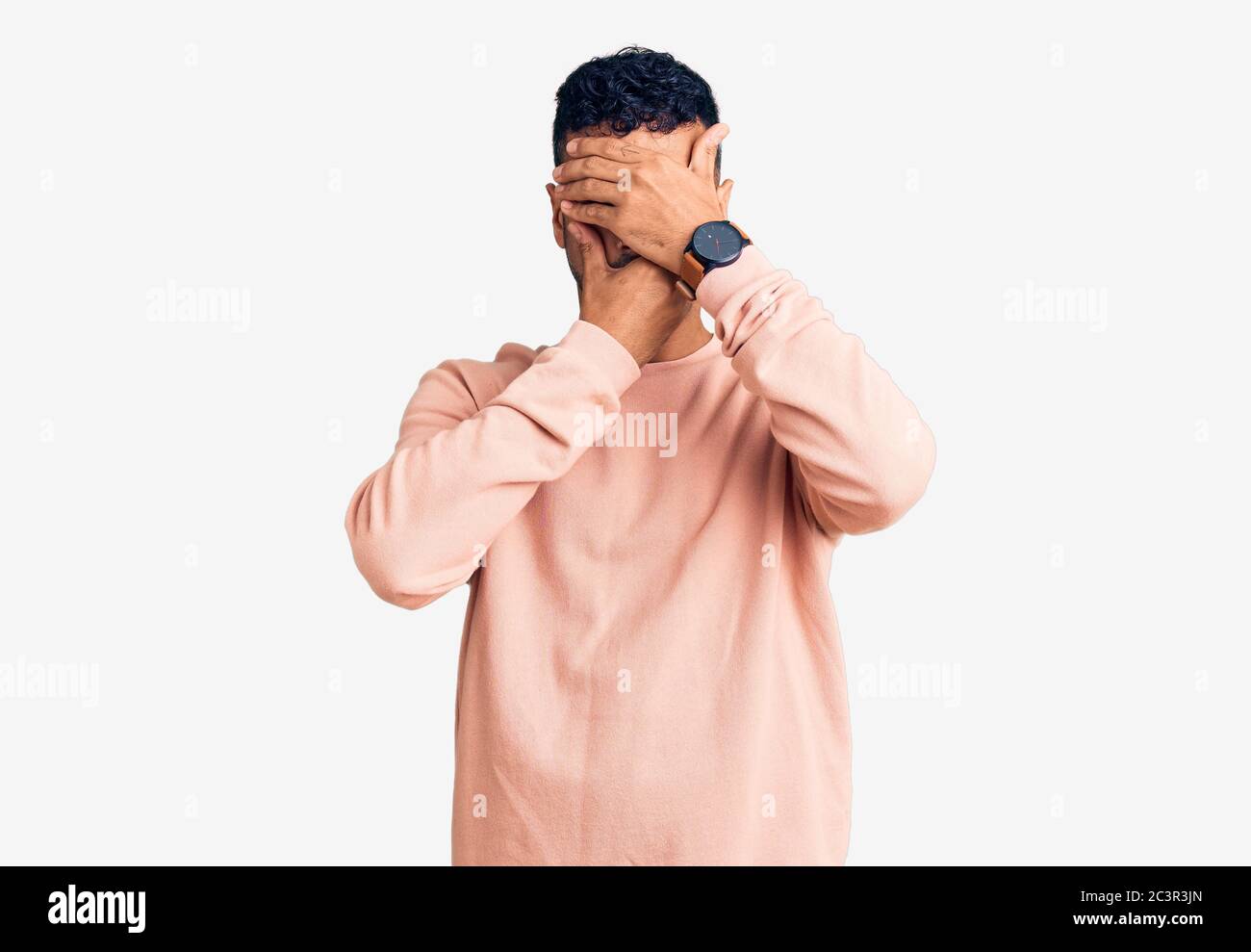 Young hispanic man wearing casual clothes covering eyes and mouth with ...