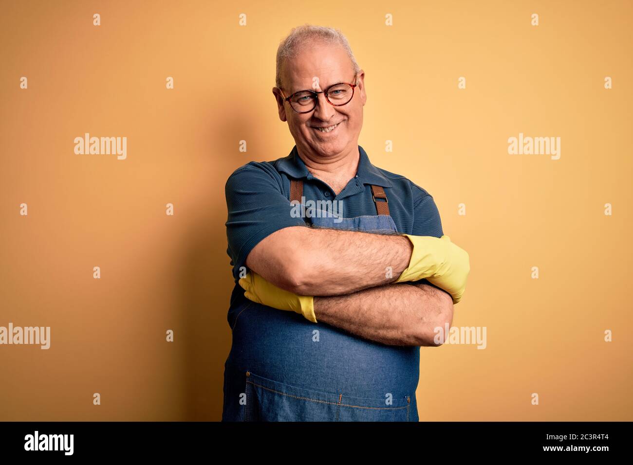 Middle age cleaner man cleaning wearing apron and gloves over isolated ...