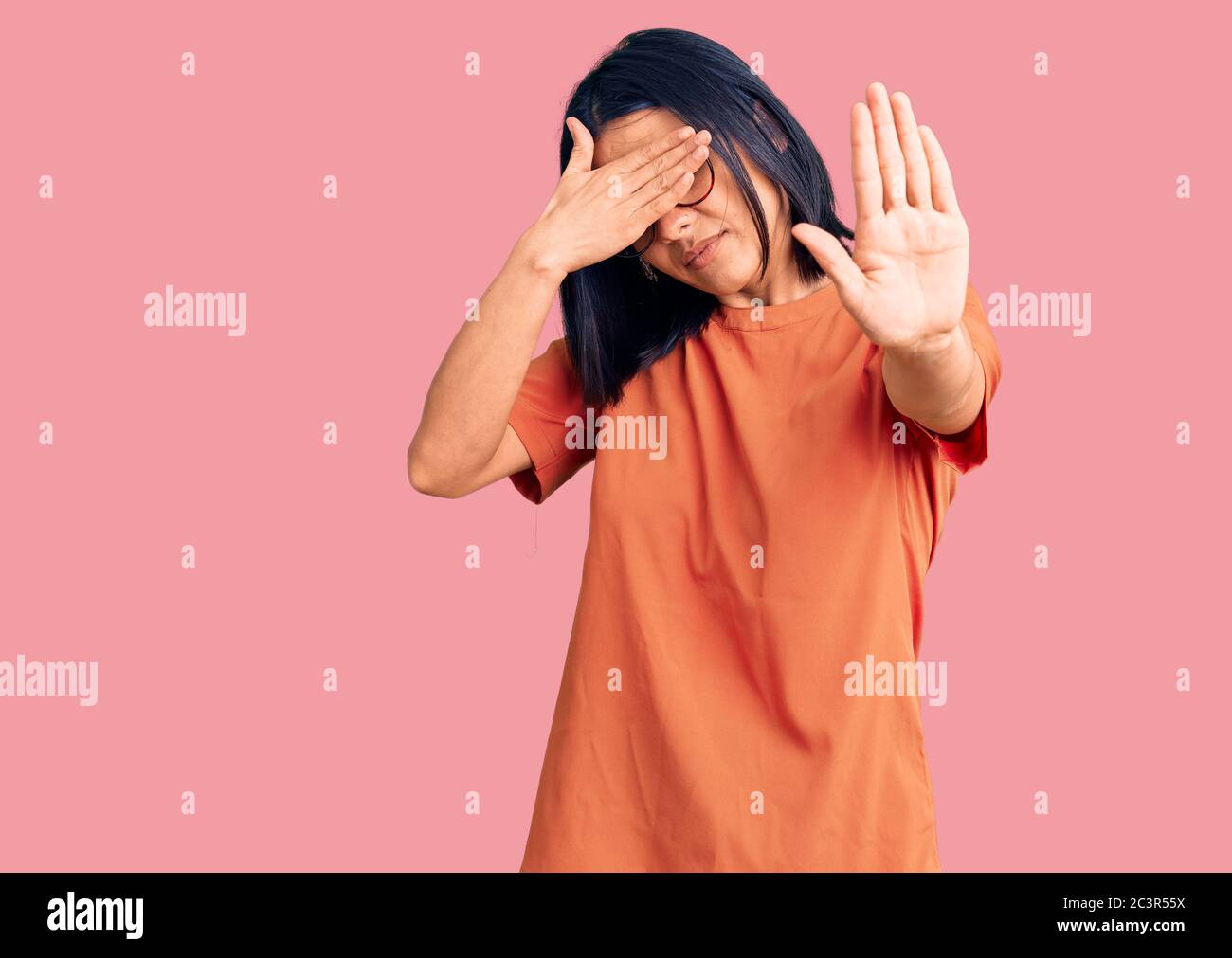 Young beautiful latin woman wearing casual clothes covering eyes with hands and doing stop gesture with sad and fear expression. embarrassed and negat Stock Photo