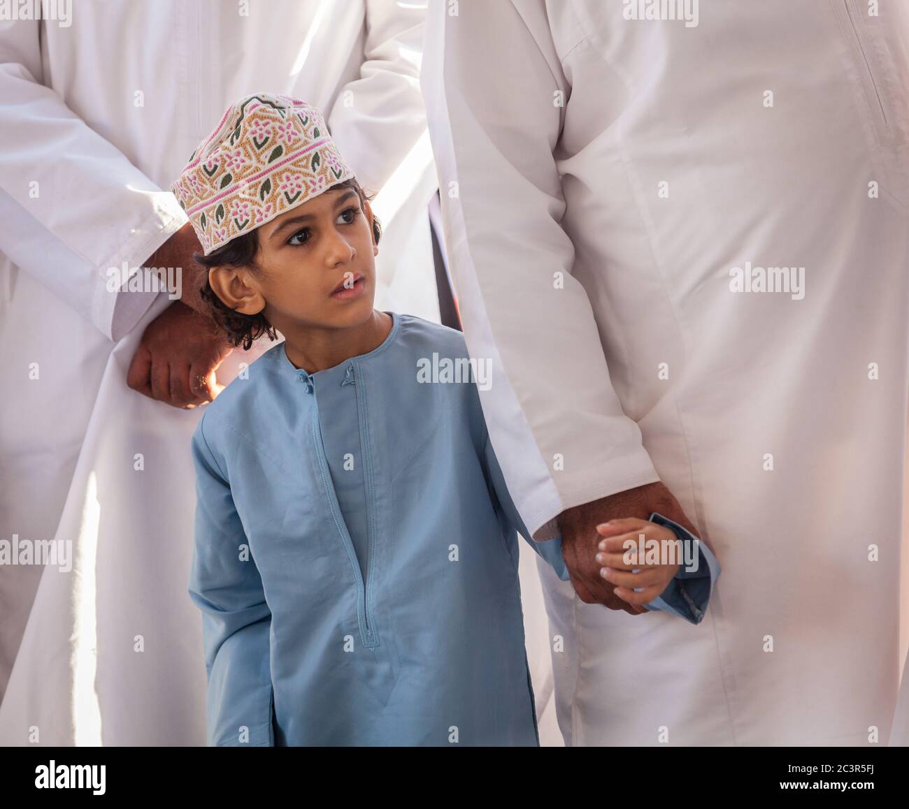 Nizwa, Oman, December 2, 2016: Portrait of a local boy in traditional clothes at the Friday goat market in Nizwa, Oman Stock Photo
