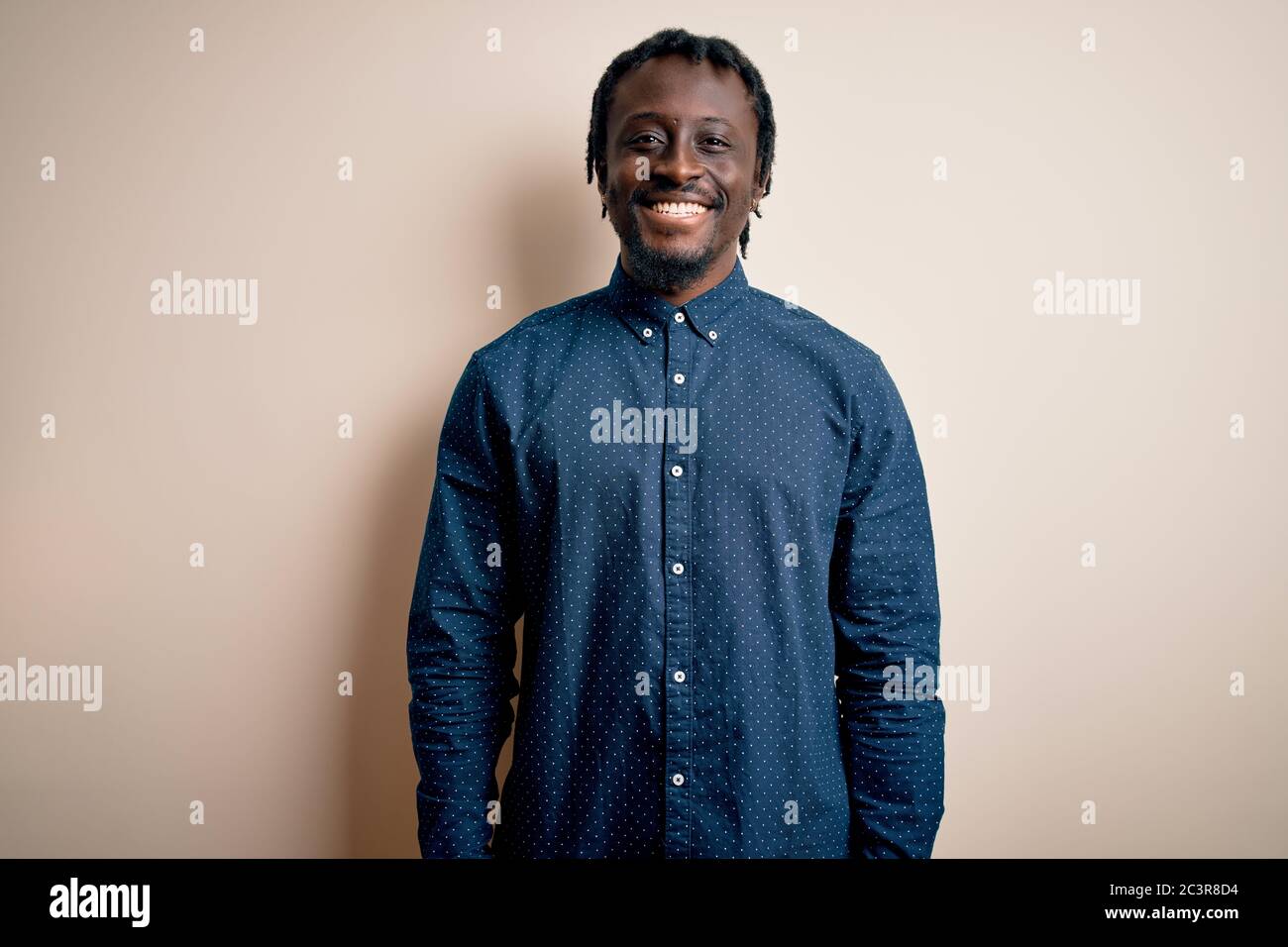 Young handsome african american man wearing casual shirt standing over ...