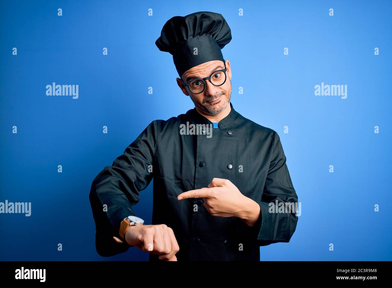 Young handsome chef man wearing cooker uniform and hat over isolated ...