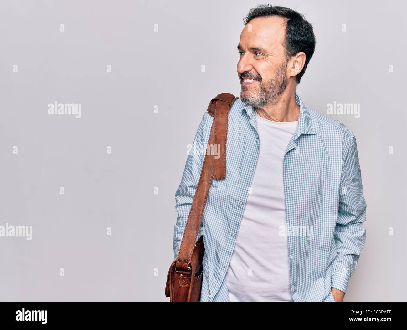 Middle age handsome businessman wearing leather bag over isolated white ...