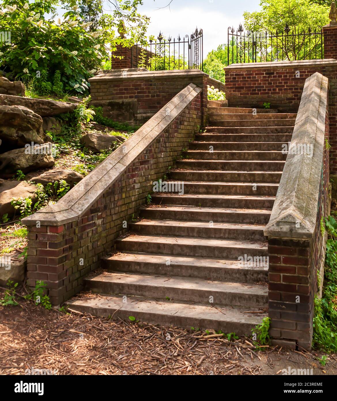 Concrete steps lined with a brick wall leading up to a landing with a