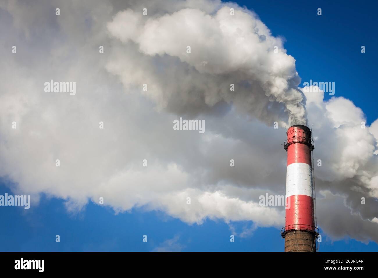 The big pipe smokes. Bright blue sky, thick white smoke. Solar lighting. Copy space. Stock Photo