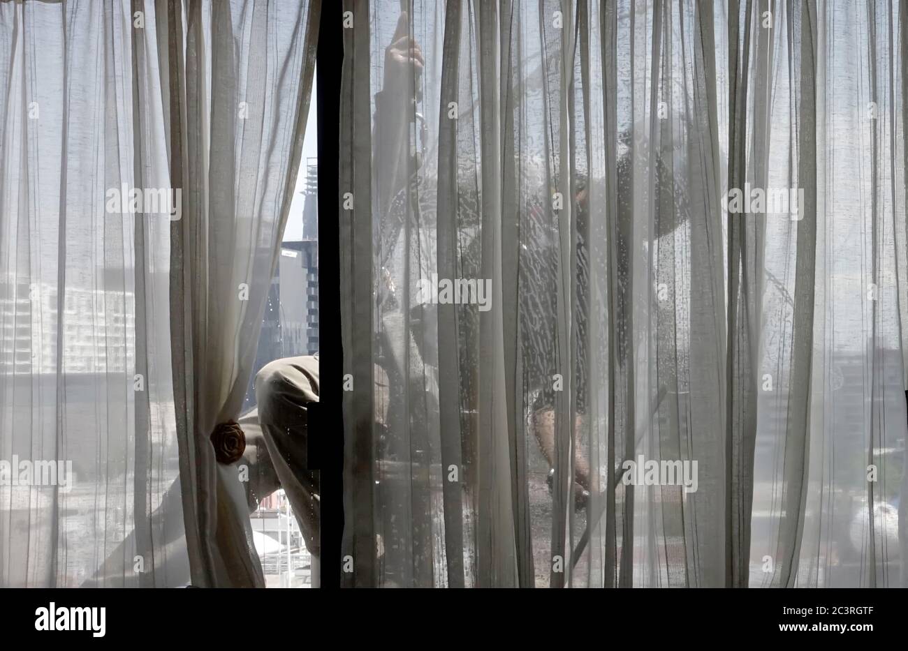 High-rise building window cleaner seen from inside room Stock Photo