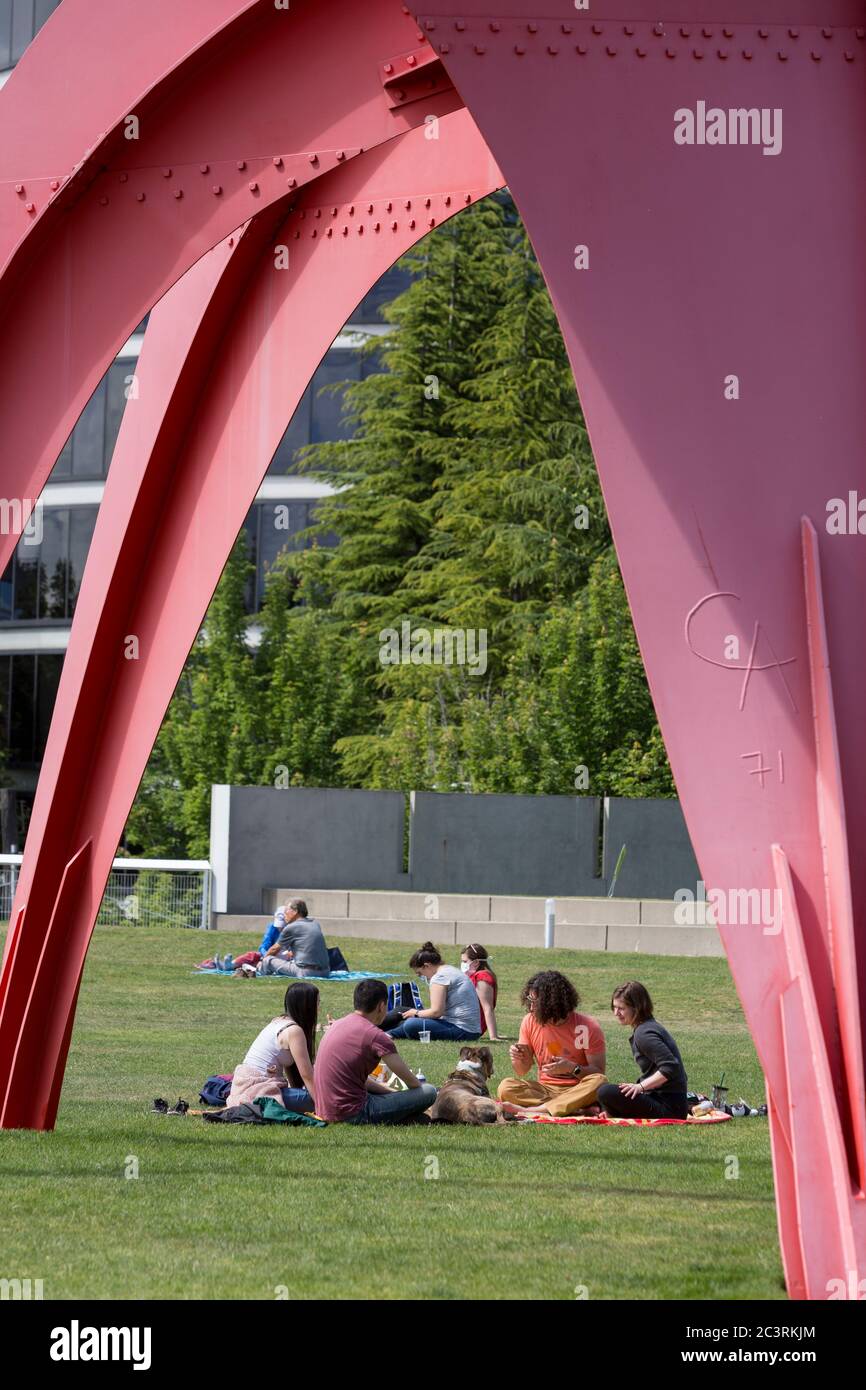Visitors relax under Alexander Calder’s sculpture “Eagle” at Olympic Sculpture Park in Seattle as coronavirus pandemic restrictions are eased on Sunday, June 21, 2020. King County moved to Phase 2 on Friday as part of governor Jay Inslee's Safe Start reopening plan allowing for increased recreational, social and business activities. Stock Photo