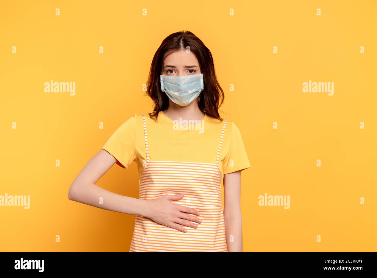 Download Sick Young Woman In Medical Mask Having Stomach Ache On Yellow Stock Photo Alamy PSD Mockup Templates