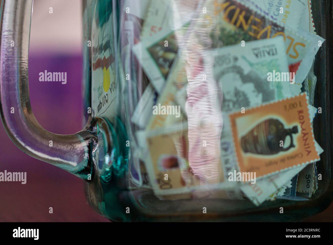 Collection of postage stamps in a jar Stock Photo