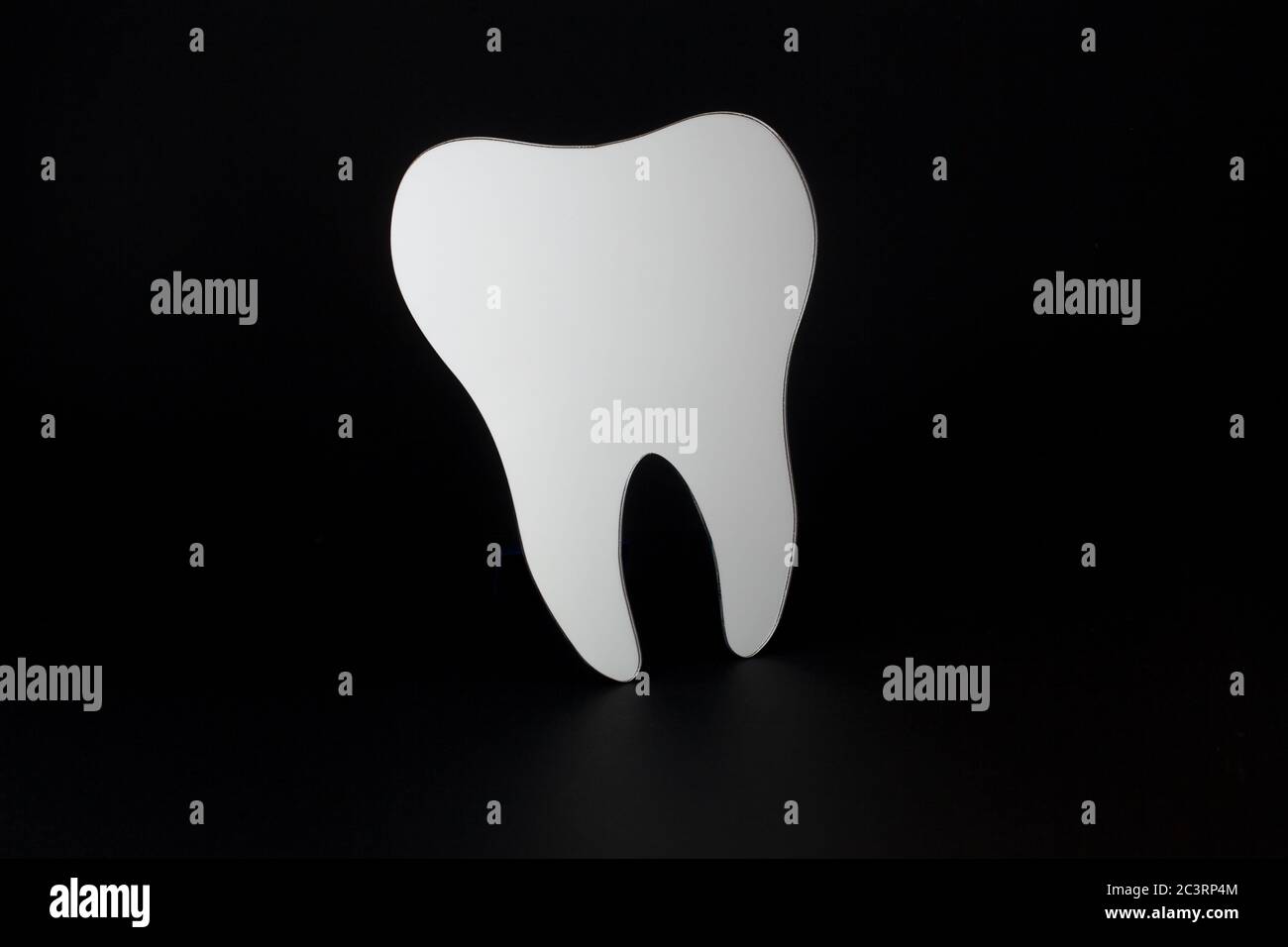 Toothshaped mirror used by dentists isolated on a black background