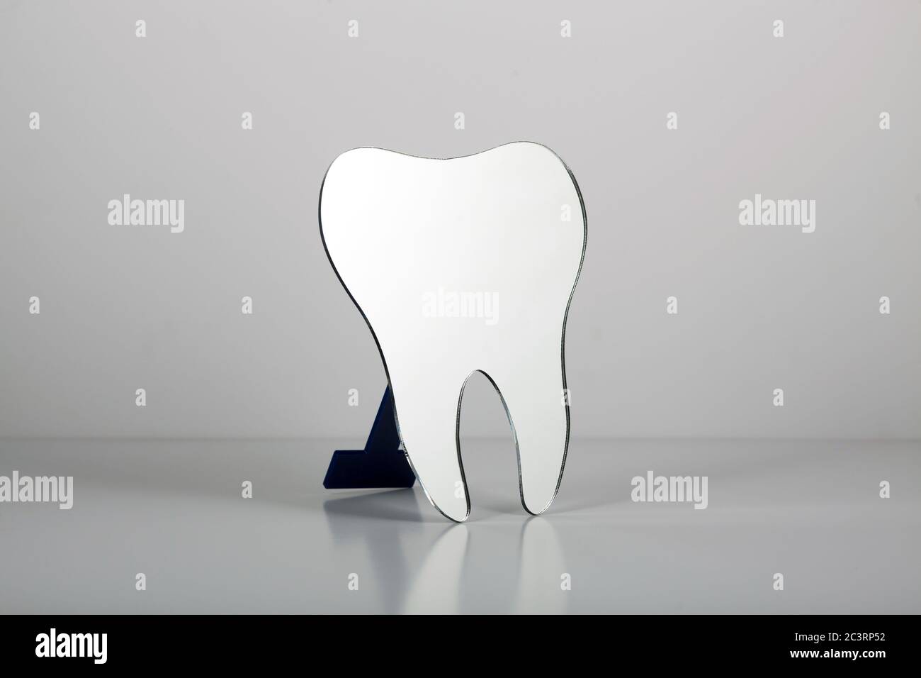 Toothshaped mirror used by dentists isolated on a white background