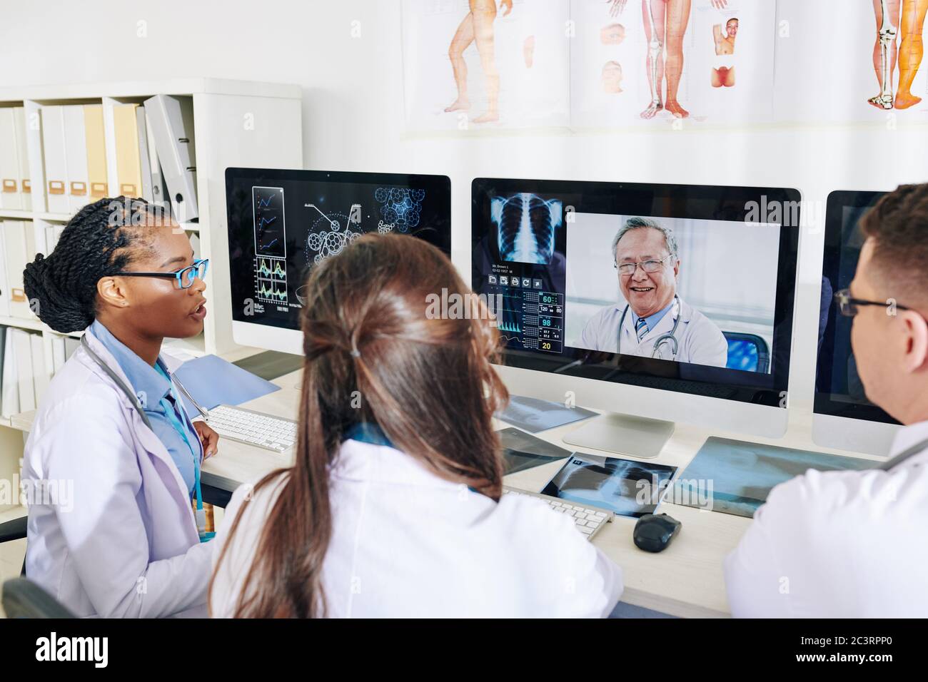 Group of young doctors discussing latest medical breakthroughs with ...