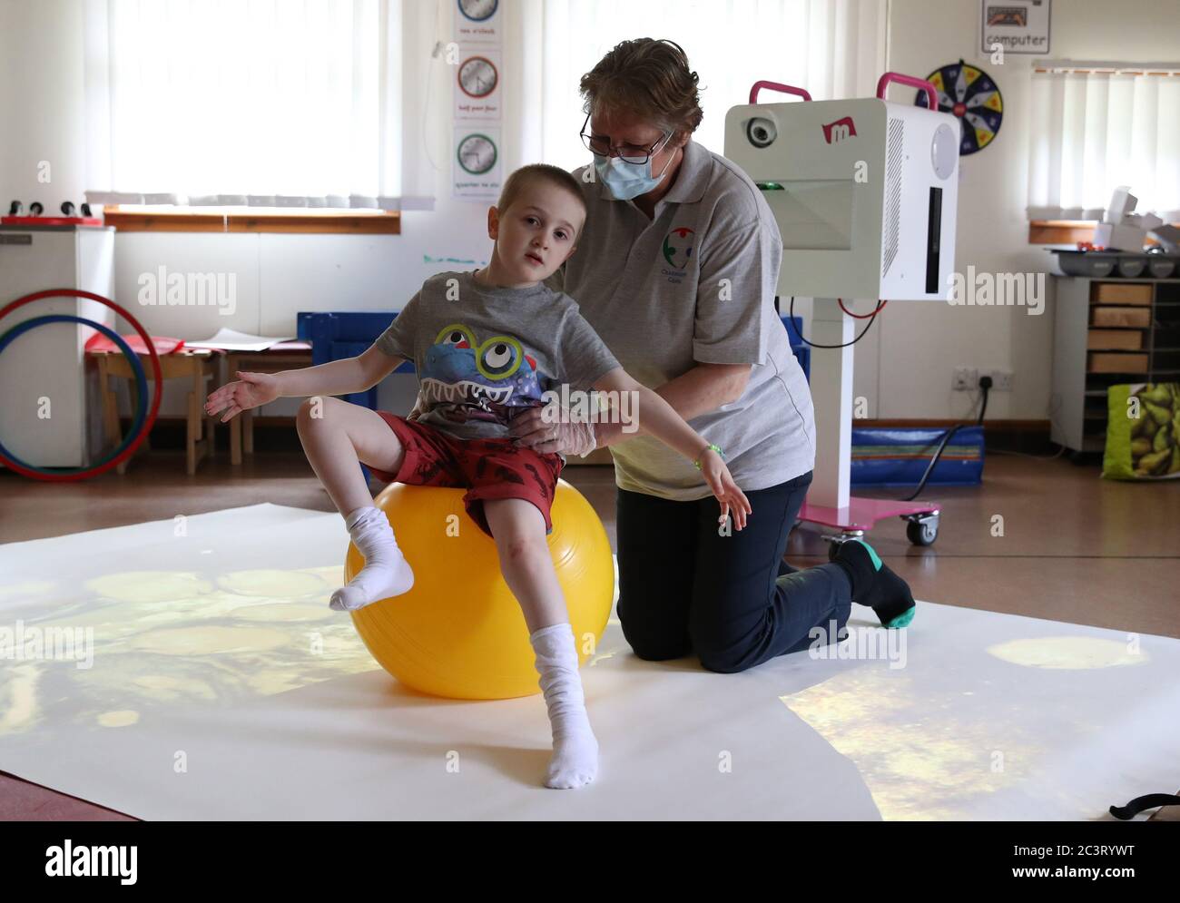 Callum McMichael alongside Paediatric Physiotherapist Kath Brimlow as he takes part in 1:1 session supporting development of posture and movement skills at the Craighalbert Centre. Coronavirus adaptations have been installed at the Scottish Centre for Children with Motor Impairments, Craighalbert Centre, Cumbernauld, as Scotland continues gradually lifting coronavirus lockdown measures. Stock Photo