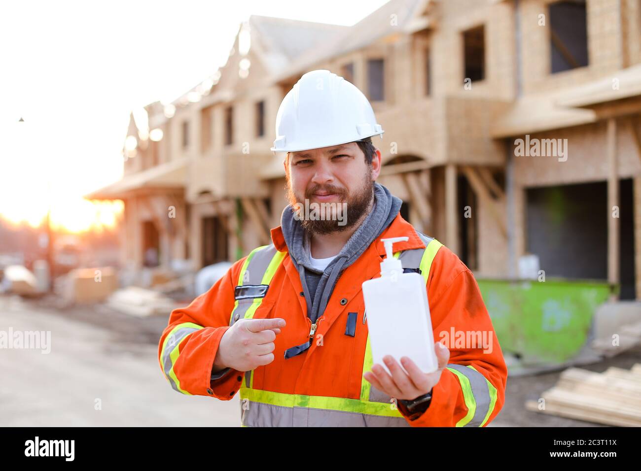 Builder worker showing disinfectant soap at construction site Stock