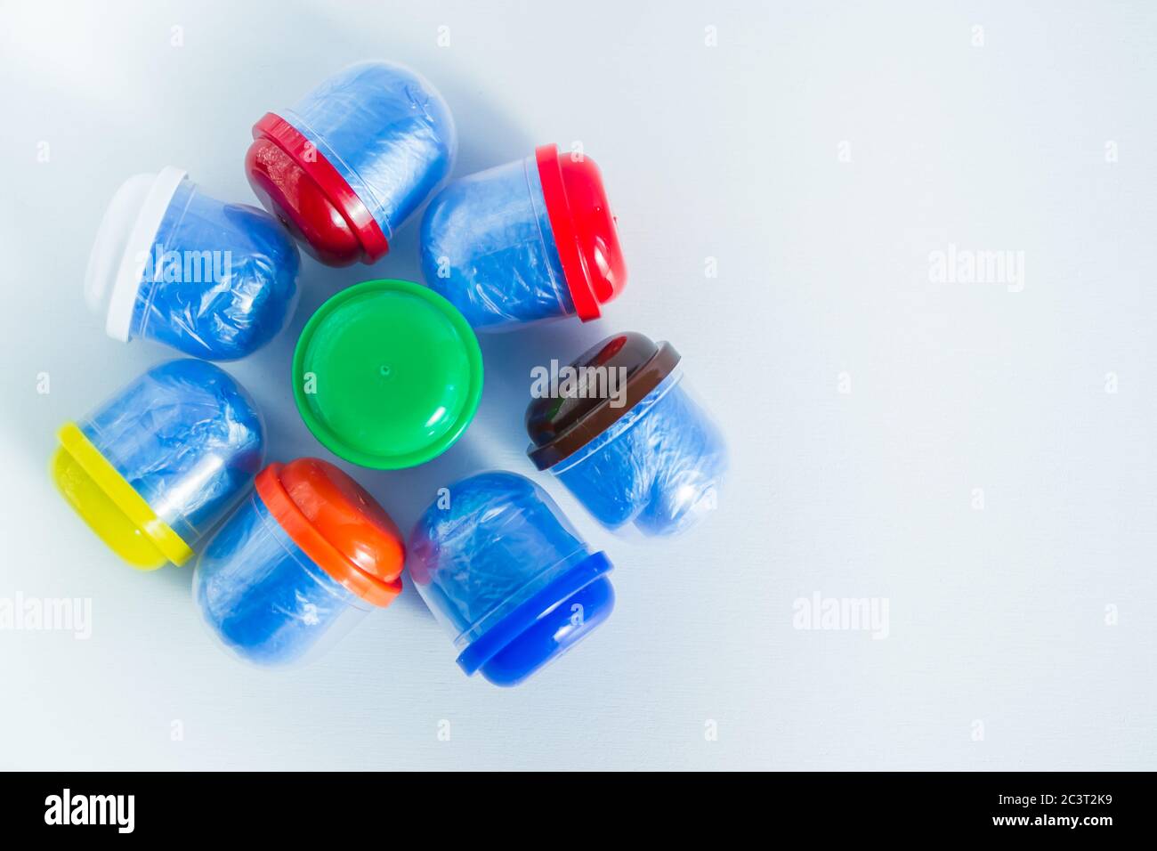 Blue shoe covers in individual capsules with multi-colored caps. Disposable shoe covers. Protection concept. Space for text Stock Photo