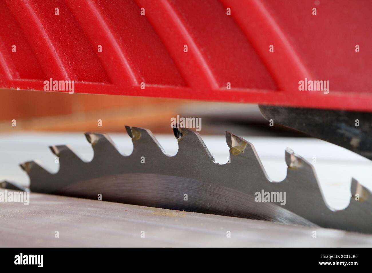 teeth on a table saw blade with red blade plastic blade guard Stock Photo