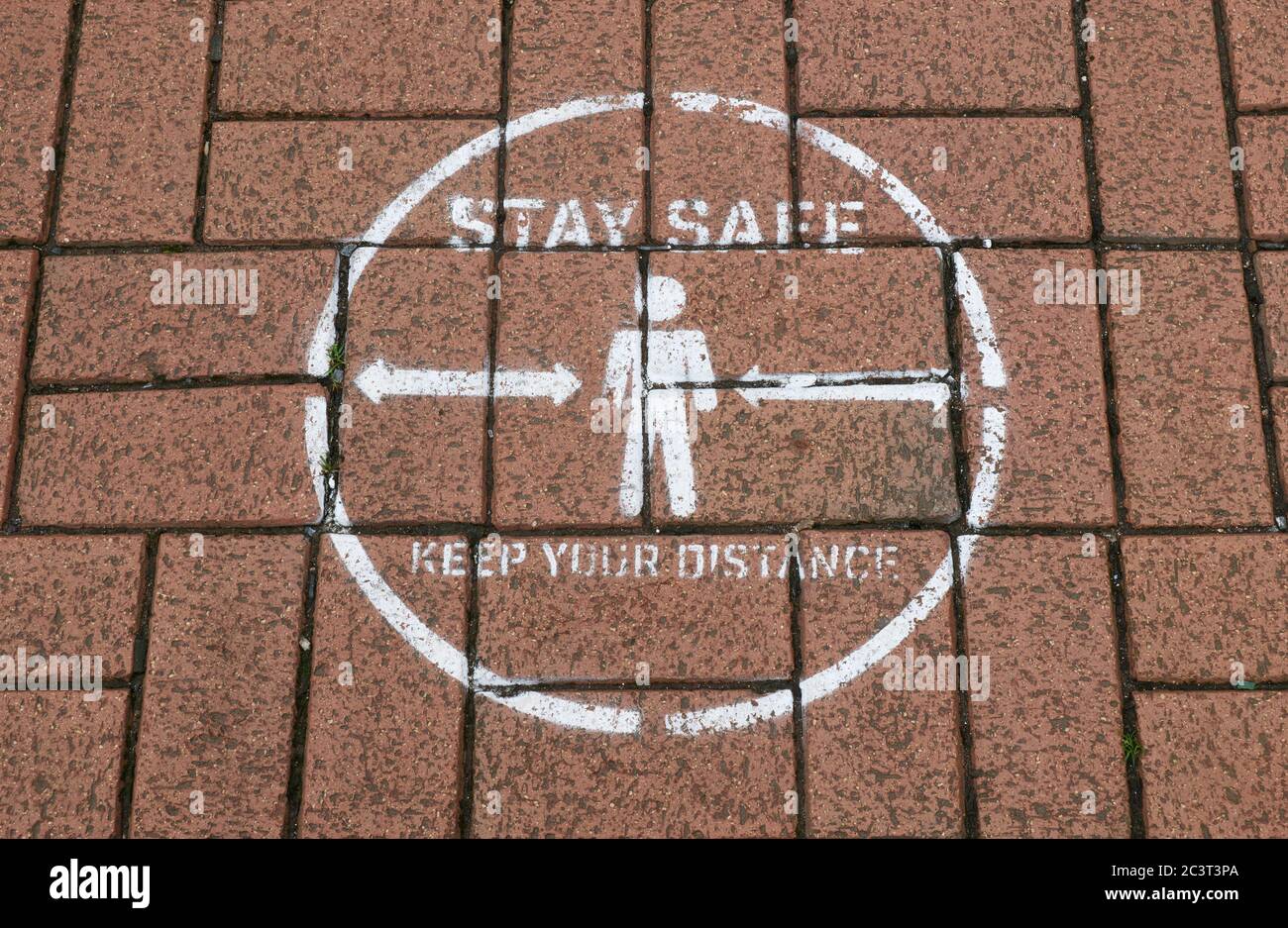 Stay safe markings / keep your distance stencilled on pavement at bus