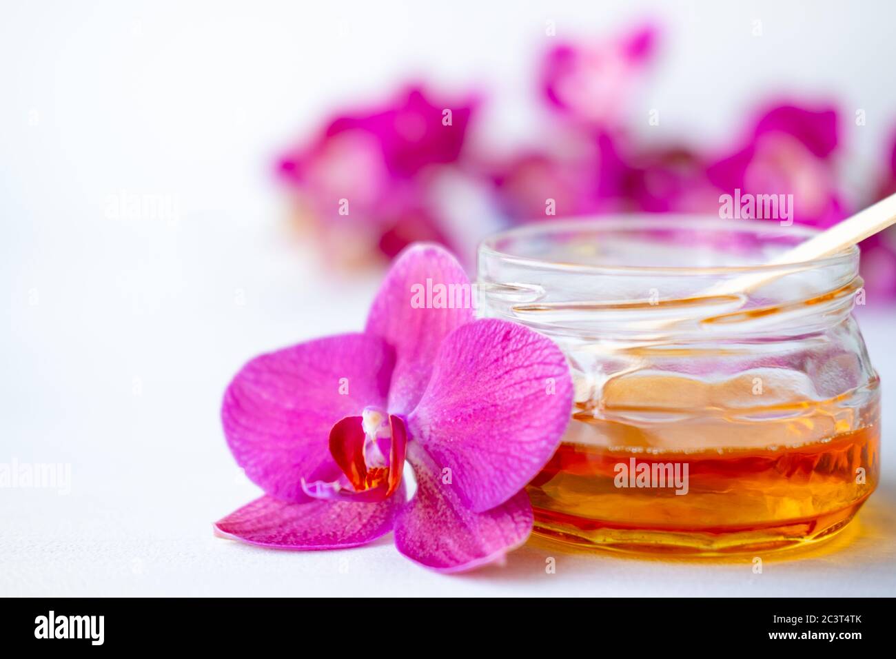sugar paste or wax honey for hair removing with wooden waxing spatula sticks. flower background - depilation and beauty concept Stock Photo