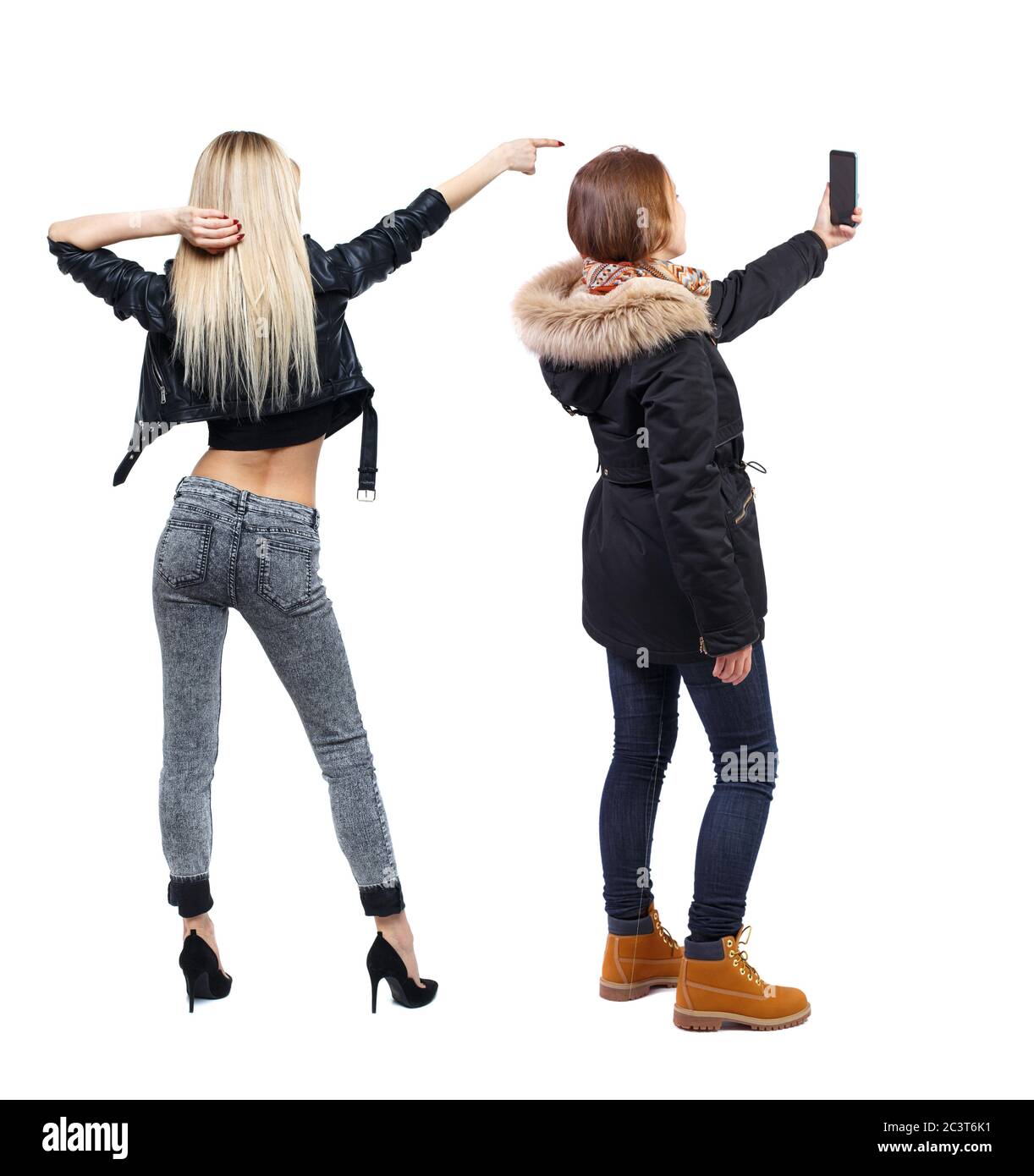 Back view of two young woman photographed on a mobile phone in winter ...