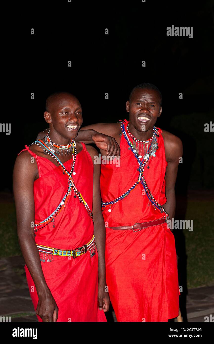 Two Maasai men smiling wearing traditional attire, in Maasai Mara National Reserve. Kenya. Africa. Stock Photo