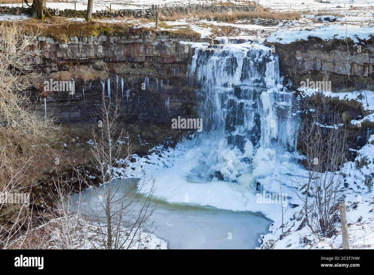 A winter view of an icy and partly frozen Hellgill Force, an attractive waterfall in the Yorkshire Dales National Park Stock Photo