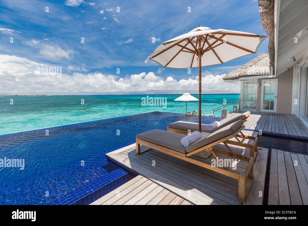 Luxury beach resort with infinity pool, loungers or beach chairs under ...