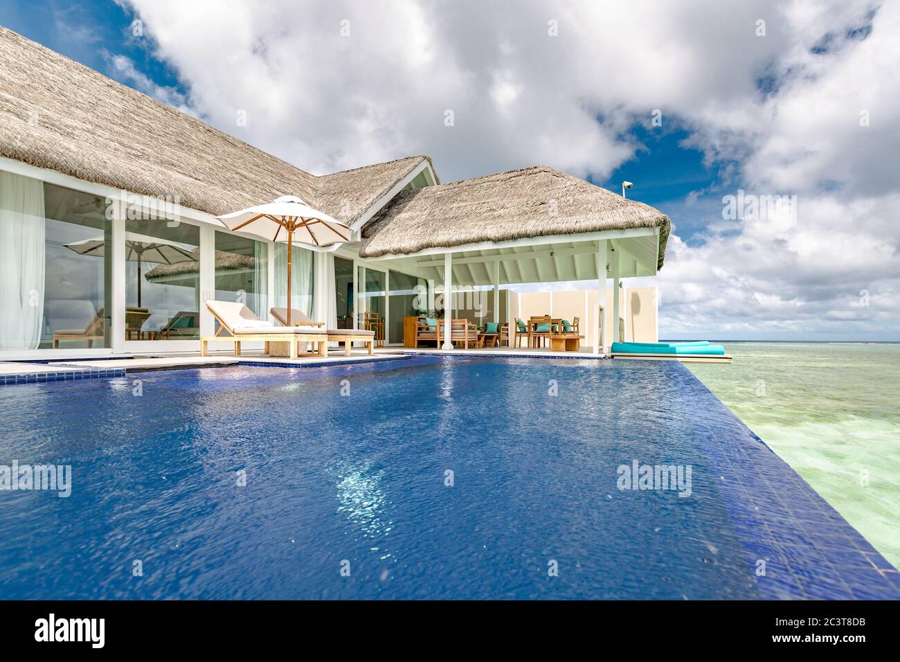 Luxury beach resort with infinity pool, loungers or beach chairs under ...