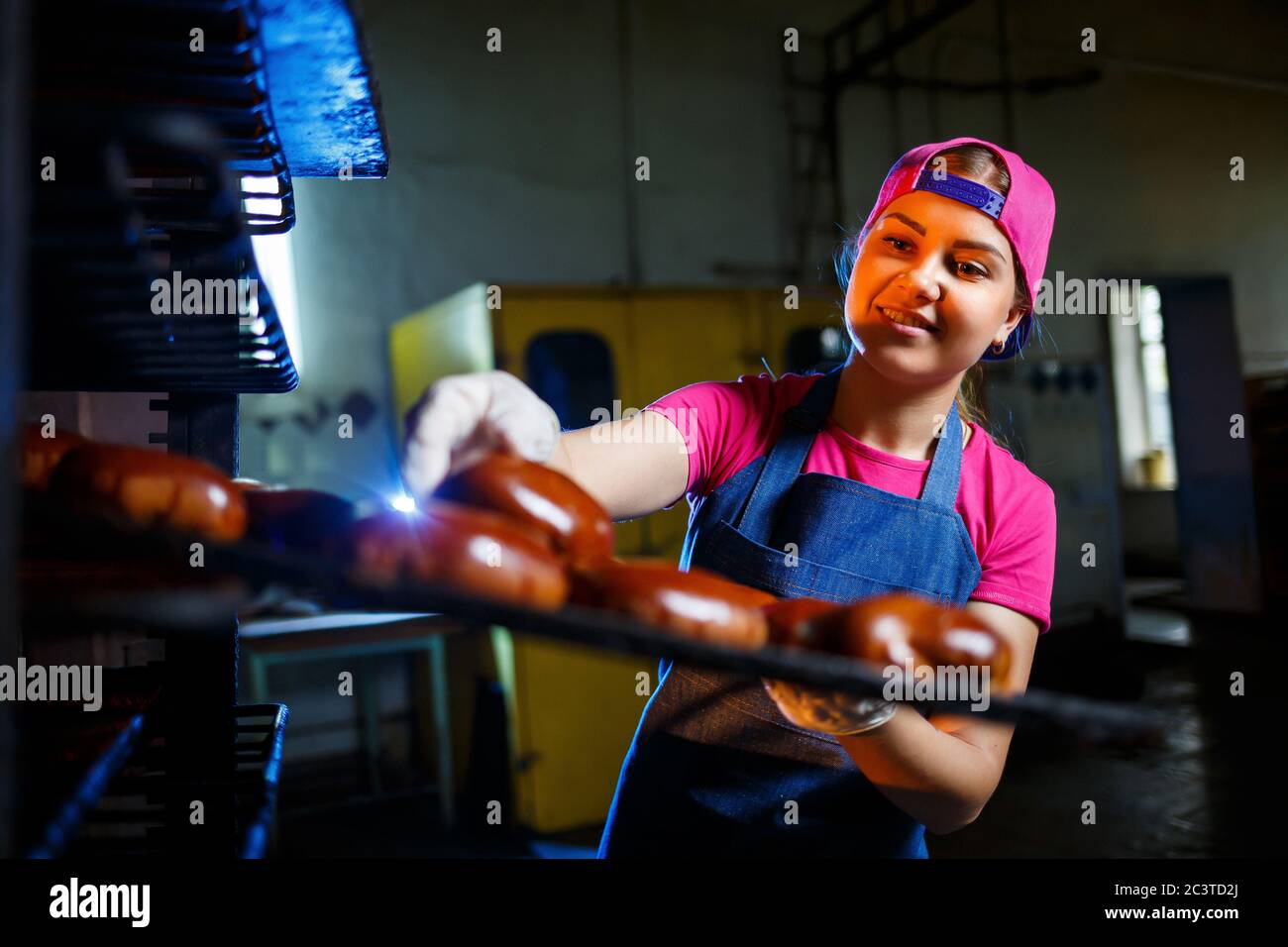 Young girl baker holds a tray with hot pastries against the background