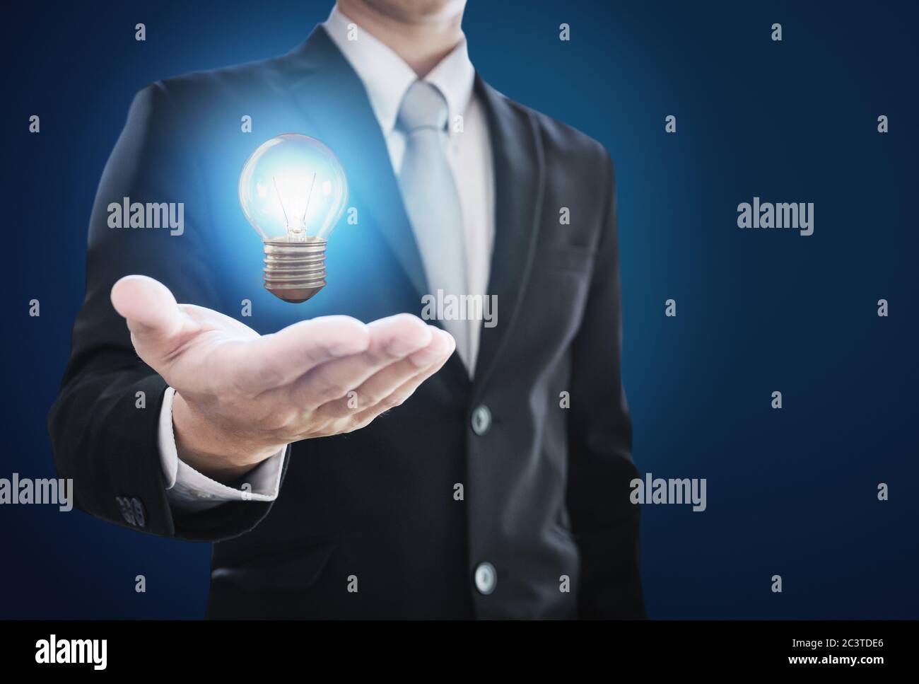 Businessman holding glowing light bulb on hand. New ideas, innovation and inspiration concept Stock Photo