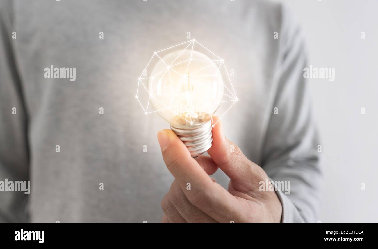 New ideas, innovation, networking and saving energy concepts. a man holding glowing light bulb Stock Photo