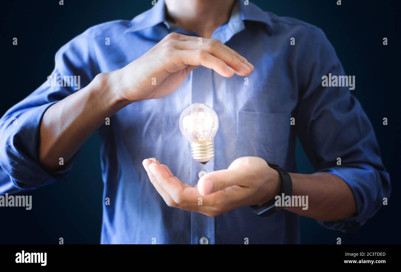 Businessman holding glowing light bulb. New ideas, innovation and saving energy concept Stock Photo