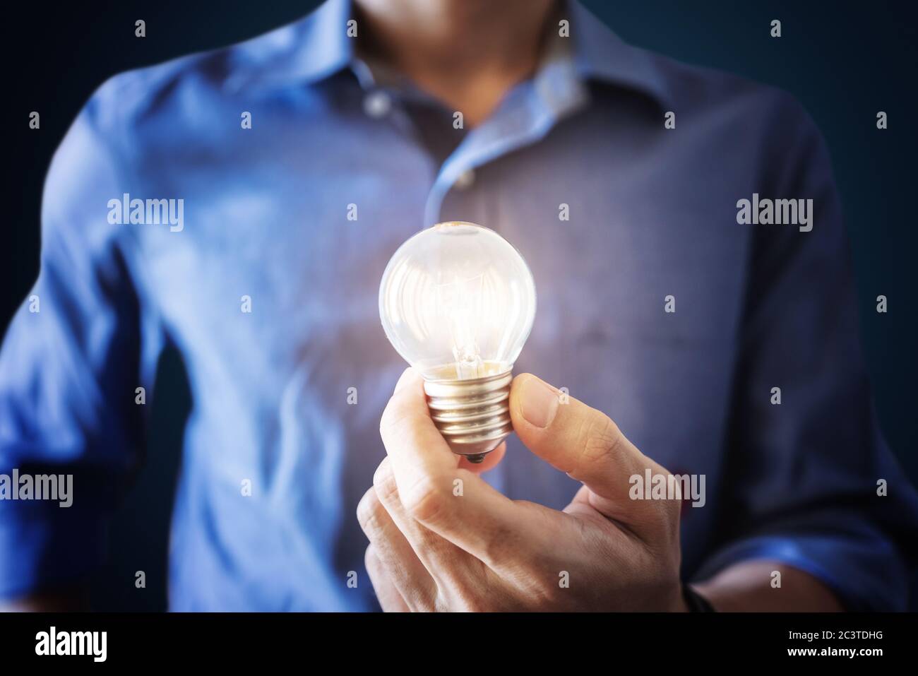 Businessman holding glowing light bulb. New ideas, innovation and saving energy concept Stock Photo