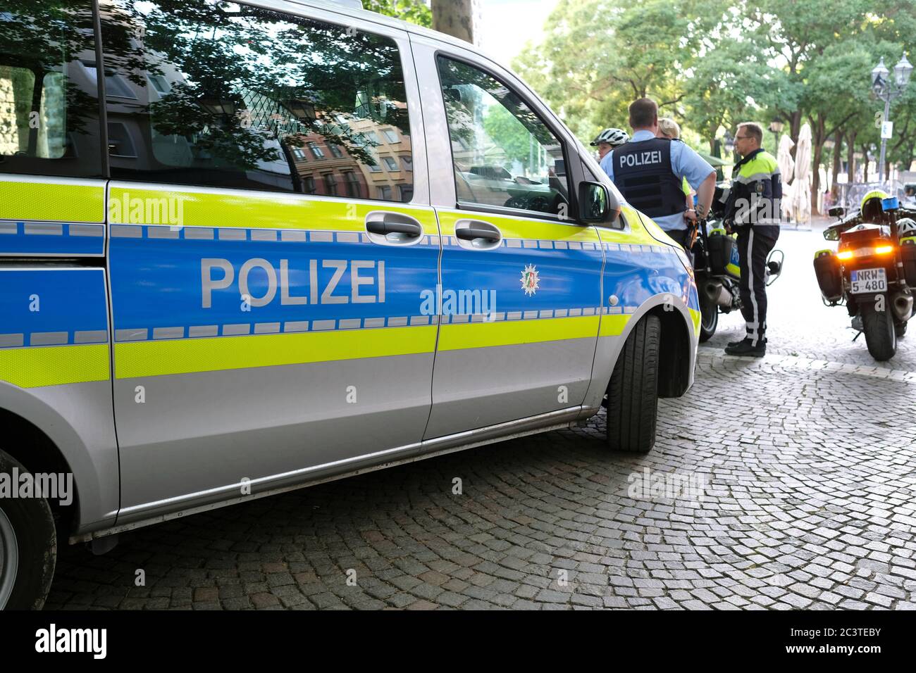 Cologne, Germany - June 20, 2020: A police car, police motorcycle and multiple policemen on 'Rudolfplatz' square in the city center Stock Photo