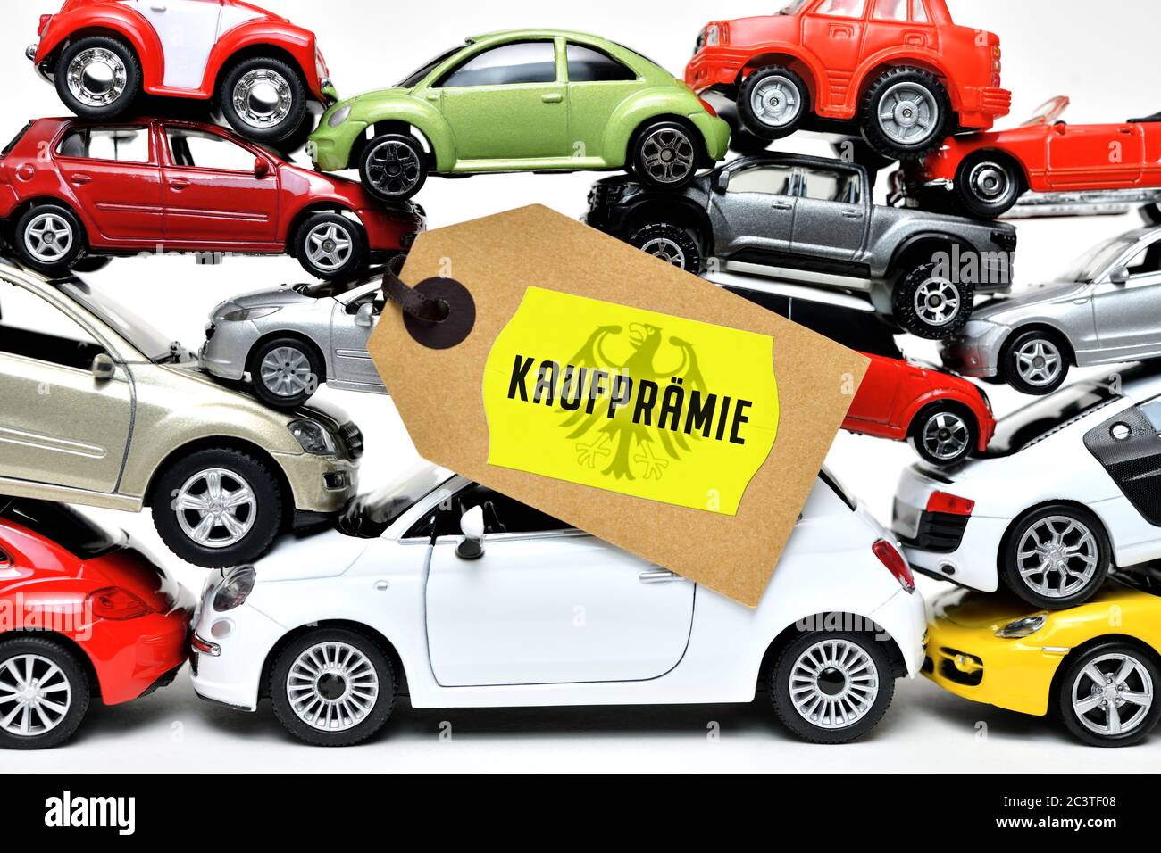 PHOTOMONTAGE, stacked toy cars with label and the label purchase premium, FOTOMONTAGE, Gestapelte Spielzeugautos mit Etikett und der Aufschrift Kaufpr Stock Photo