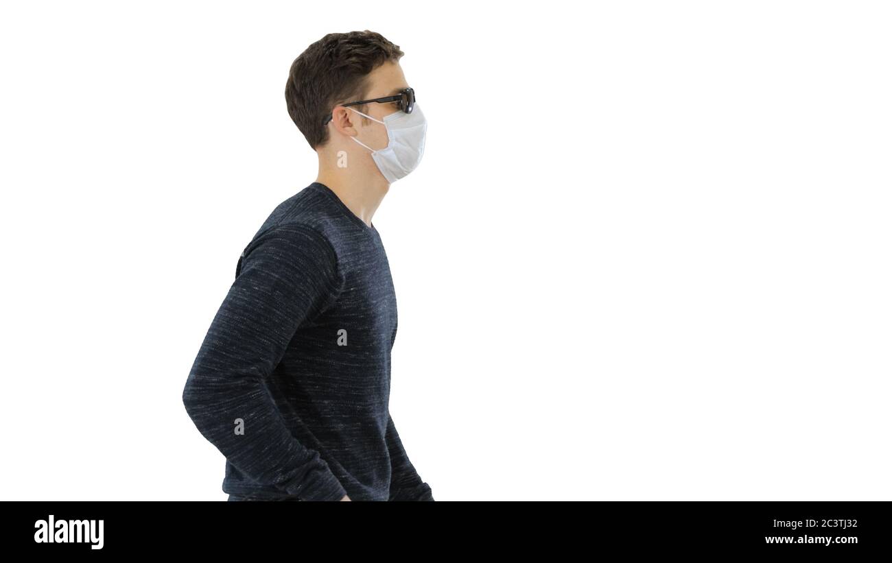 Young blind person with long cane and medical mask walking on white