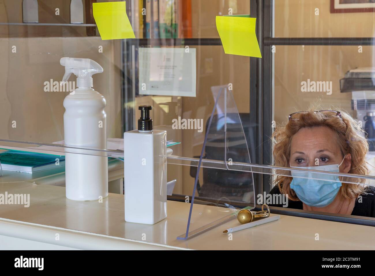 The new way of working imposed by the needs to avoid possible contagions from Covid-19 coronavirus, with plexiglass screen and mask Stock Photo