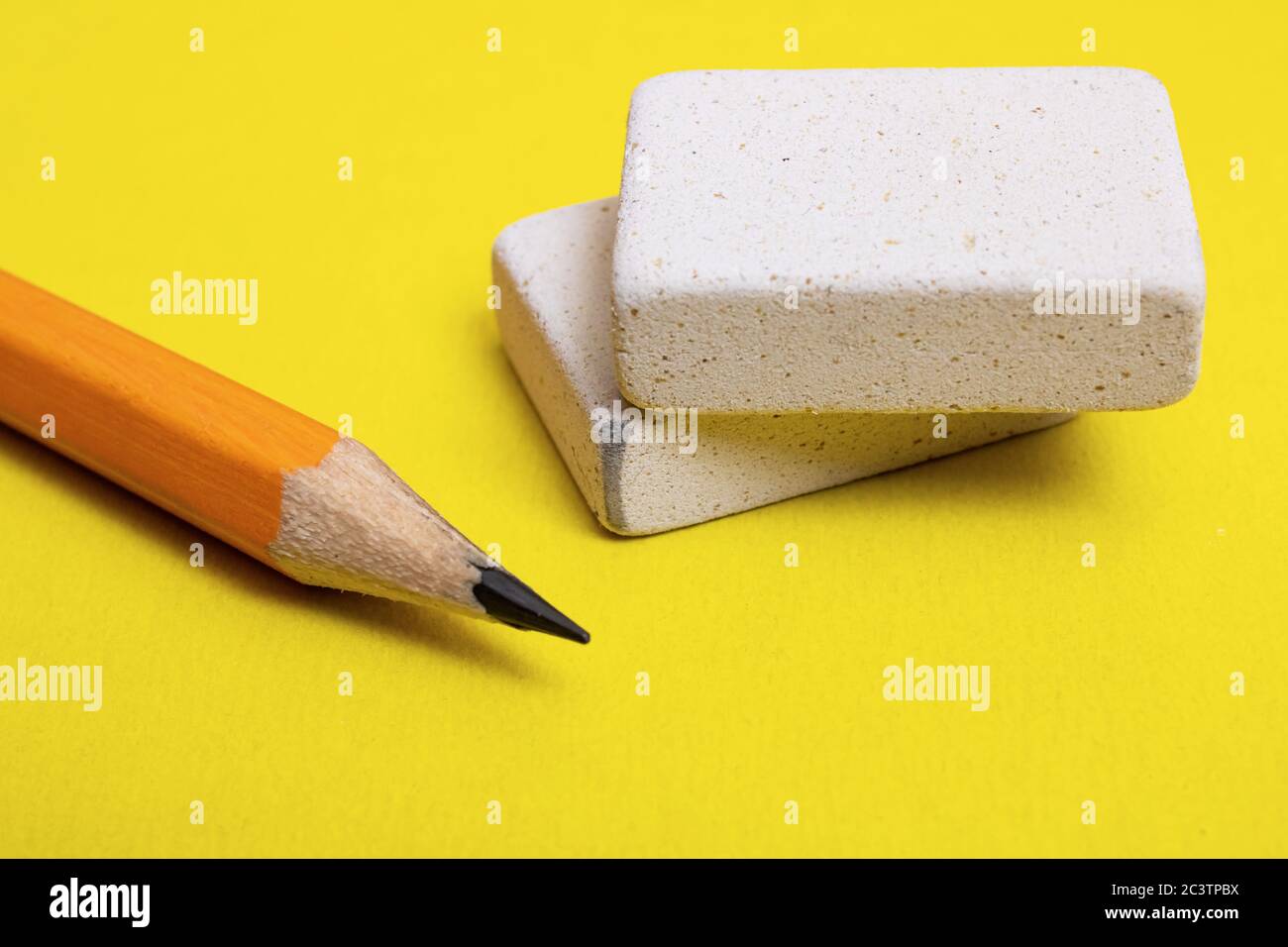 Two erasers and pencil on a yellow background Stock Photo