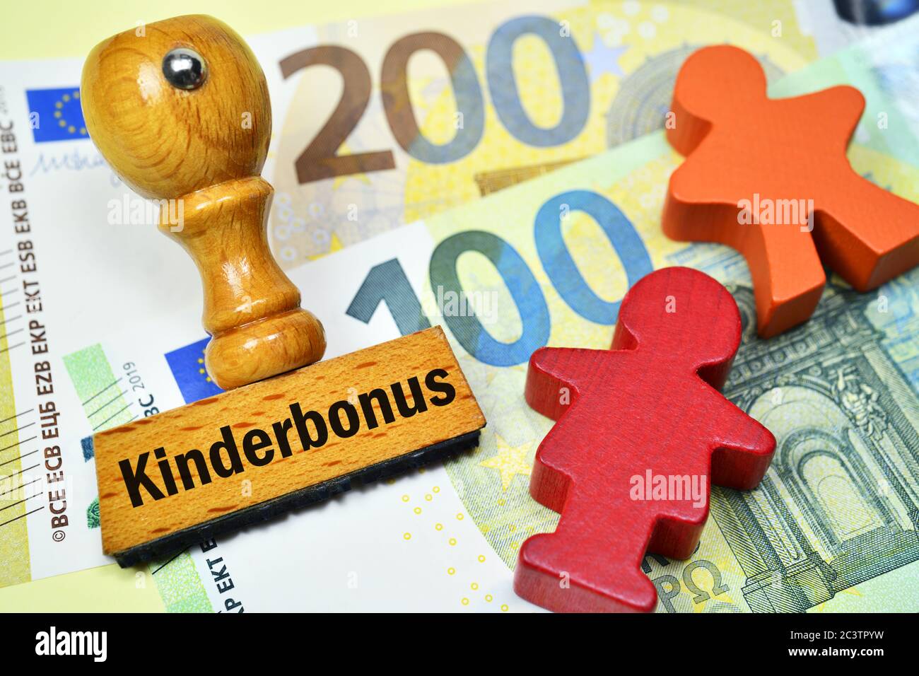 PHOTOMONTAGE, stamp with the word child bonus and children figurines on banknotes, symbol Photo 300 euro child bonus, FOTOMONTAGE, Stempel mit Aufschr Stock Photo