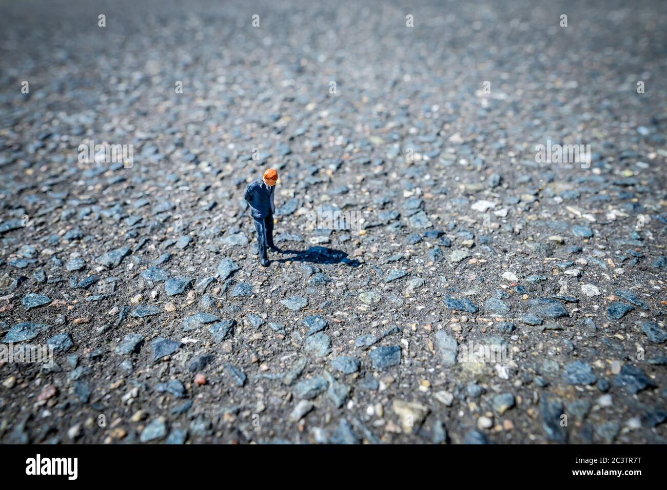 Miniature figure on a road icon photo for the little man in the street, petty bourgeois philistines, Miniaturfigur auf einer Straße, Symbolfoto für de Stock Photo