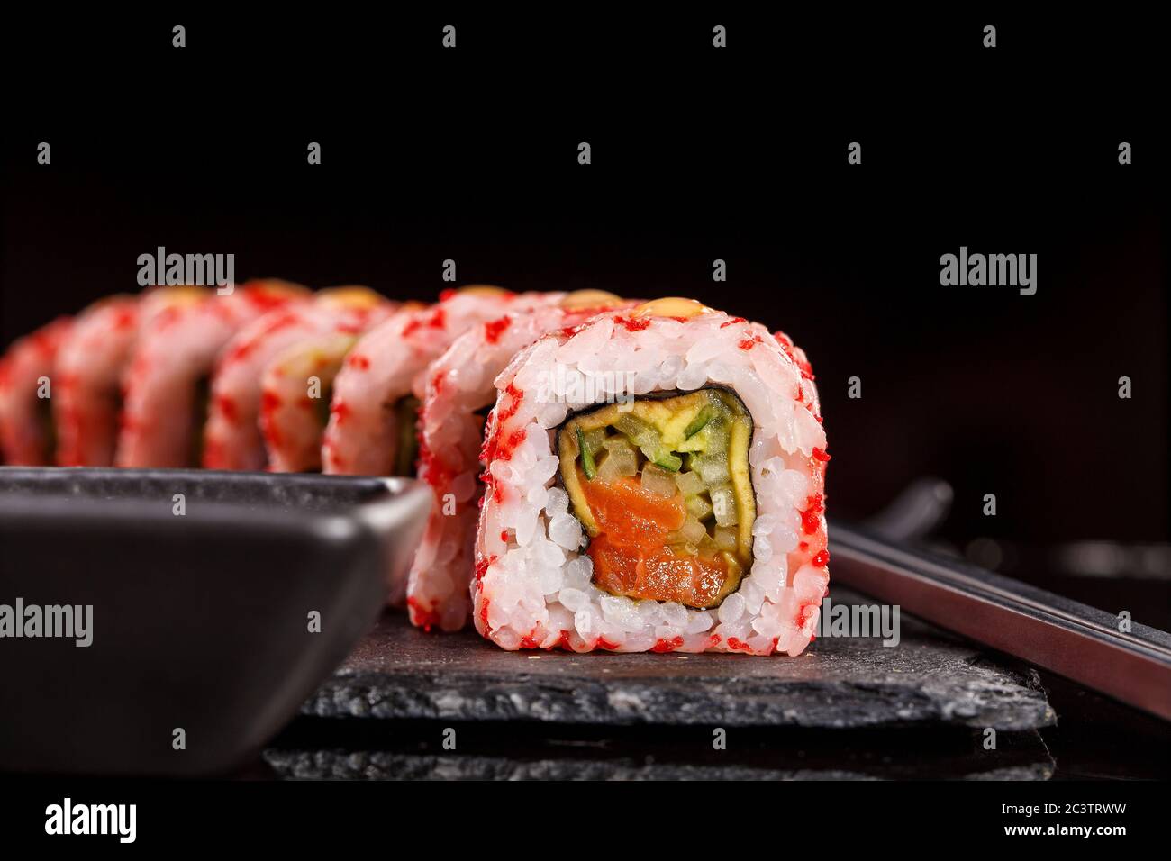 Japanese sushi with soy sauce and chopsticks on black background Stock