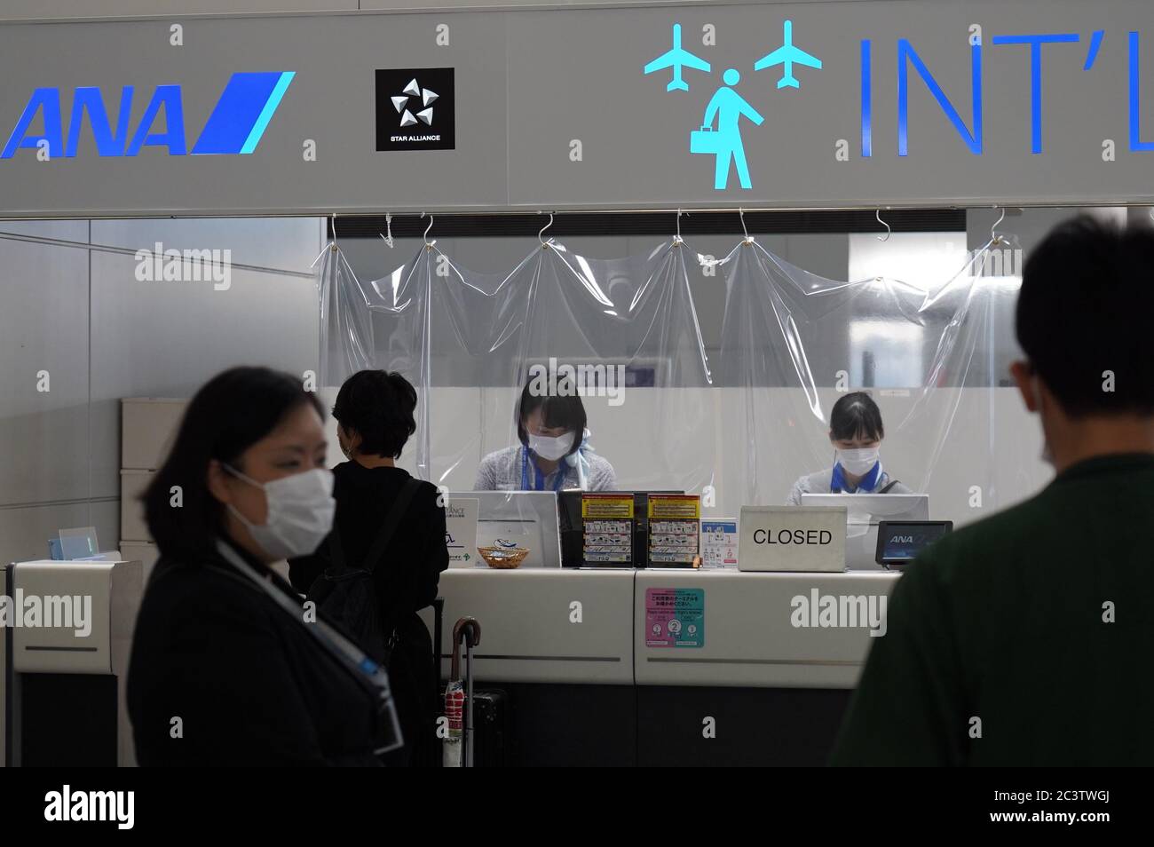 Airline staff attend to passengers while wearing face masks as a preventive measure at the Chubu Centrair International Airport.Japan's government lifted all COVID-19 related restrictions on domestic travels on June 19 while most of the international flights remain cancelled. Stock Photo
