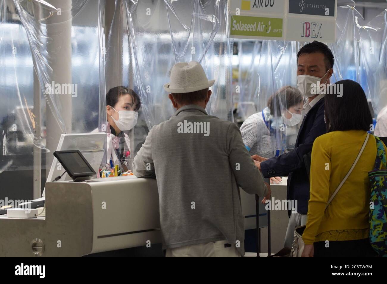 Airline staff attend to passengers while wearing face masks as a