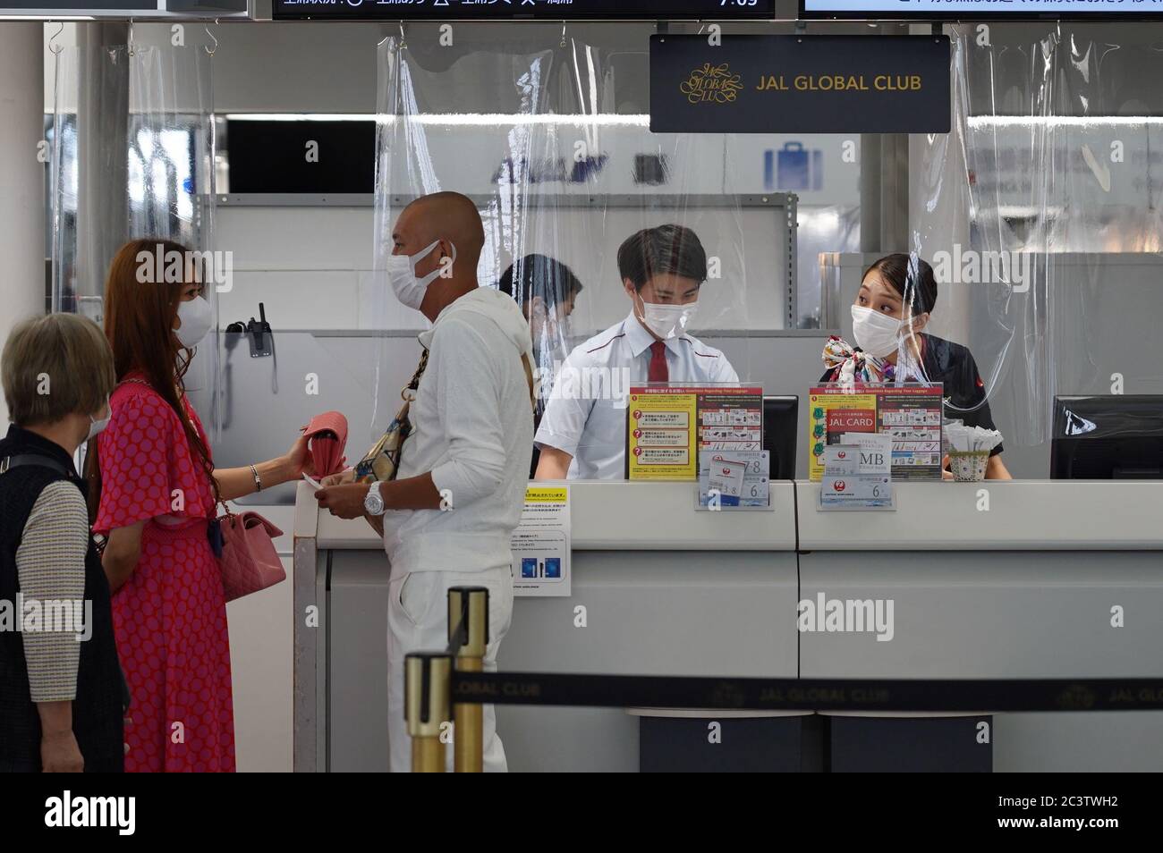Airline staff attend to passengers while wearing face masks as a preventive measure at the Chubu Centrair International Airport.Japan's government lifted all COVID-19 related restrictions on domestic travels on June 19 while most of the international flights remain cancelled. Stock Photo