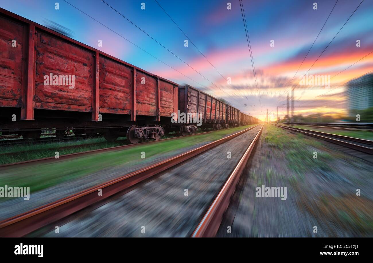 Moving freight train at sunset. Railroad and beautiful sky Stock Photo